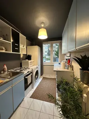 a kitchen with white cabinets and a stove top oven at Pokój z parkingiem 20 minut piechotą od Rynku Głównego i Dworca Głównego in Kraków