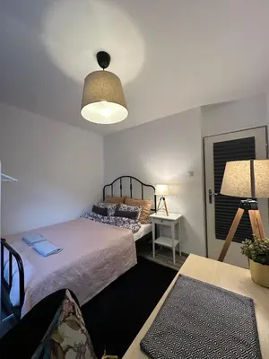 a bedroom with a bed and a table with a lamp at Pokój z parkingiem 20 minut piechotą od Rynku Głównego i Dworca Głównego in Kraków