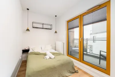 a bedroom with a bed and a large window at Malila Premium Apartments Cracow Rakowicka 20L- 453 in Kraków