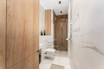 a bathroom with a white toilet and a sink at Malila Premium Apartments Cracow Rakowicka 20L- 453 in Kraków