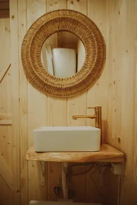 a bathroom with a sink and a mirror on a wooden wall at Domki pod Halą Krupową - Chata na szlaku in Sidzina