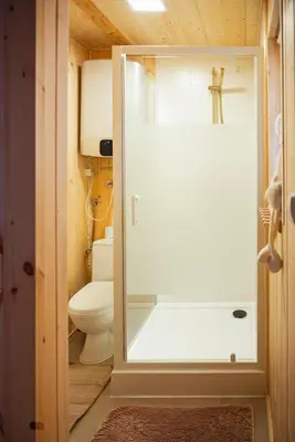 a bathroom with a toilet and a glass shower door at Domki pod Halą Krupową - Chata na szlaku in Sidzina