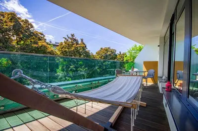 a balcony with a hammock and a view of trees at Family Apartment with 2 bedrooms, huge balcony, Free parking, 10 minutes walk to Main Square and Kazimierz District in Kraków