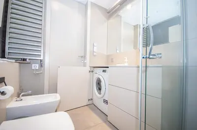 a bathroom with a sink and a washing machine at Family Apartment with 2 bedrooms, huge balcony, Free parking, 10 minutes walk to Main Square and Kazimierz District in Kraków