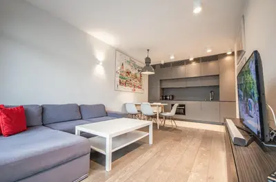 a living room with a couch and a table and a tv at Family Apartment with 2 bedrooms, huge balcony, Free parking, 10 minutes walk to Main Square and Kazimierz District in Kraków