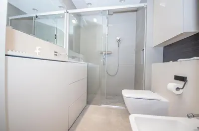a white bathroom with a shower and a toilet at Family Apartment with 2 bedrooms, huge balcony, Free parking, 10 minutes walk to Main Square and Kazimierz District in Kraków