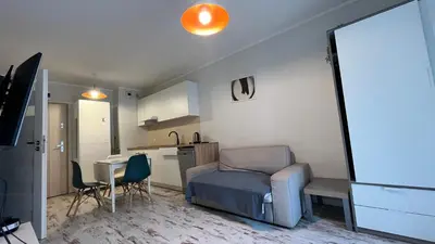 a room with a bed and a table and a kitchen at Ślusarska Street in Kraków