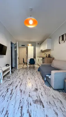 a bedroom with a bed and a desk and a kitchen at Ślusarska Street in Kraków