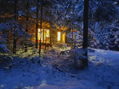 a house in the snow at night at Domki pod Halą Krupową - Tiny House w Lesie in Sidzina