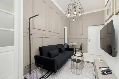 a living room with a black couch and a table at Cosy Apartments with Air Conditioning by Noclegi Renters in Kraków