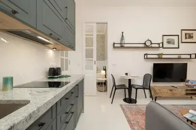a kitchen with a counter top and a dining room at Cosy Apartments with Air Conditioning by Noclegi Renters in Kraków