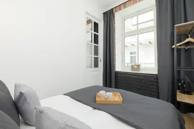 a bed with a tray with two candles on it at Cosy Apartments with Air Conditioning by Noclegi Renters in Kraków
