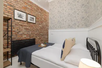 two beds in a room with a brick wall at Cosy Apartments with Air Conditioning by Noclegi Renters in Kraków