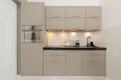 a white kitchen with white cabinets and appliances at Cosy Apartments with Air Conditioning by Noclegi Renters in Kraków