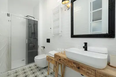 a bathroom with a sink and a toilet and a mirror at Cosy Apartments with Air Conditioning by Noclegi Renters in Kraków