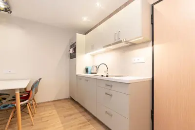 a small kitchen with a sink and a table at Studio Apartment with projector and balcony between Main Square and Kazimierz Quarter in Kraków