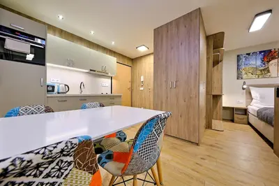 a kitchen and living room with a large white counter and chairs at Studio Apartment with projector and balcony between Main Square and Kazimierz Quarter in Kraków