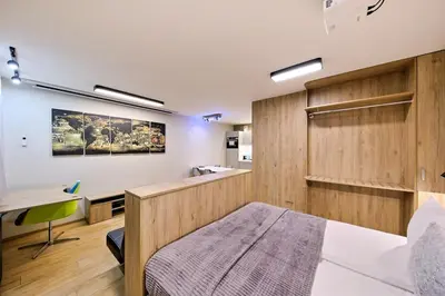 a bedroom with a bed and a desk in a room at Studio Apartment with projector and balcony between Main Square and Kazimierz Quarter in Kraków