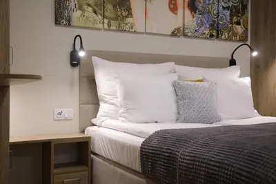 a bedroom with a bed with white sheets and pillows at Studio Apartment with projector and balcony between Main Square and Kazimierz Quarter in Kraków