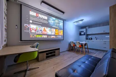 a large screen in a room with a couch and a table at Studio Apartment with projector and balcony between Main Square and Kazimierz Quarter in Kraków