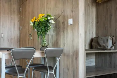a vase of flowers sitting on a table with chairs at Unique Studio Apartment with 2 balconies with Wawel Castle and city views in Kraków