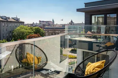 a balcony with two chairs and a view of a city at Unique Studio Apartment with 2 balconies with Wawel Castle and city views in Kraków