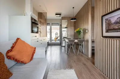 a living room with a couch and a table at Unique Studio Apartment with 2 balconies with Wawel Castle and city views in Kraków