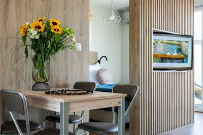 a vase of sunflowers sitting on a table in a room at Unique Studio Apartment with 2 balconies with Wawel Castle and city views in Kraków