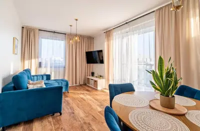 a living room with a table and blue chairs at Zoya Apartament in Kraków