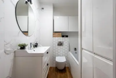 a white bathroom with a sink and a mirror at Zoya Apartament in Kraków