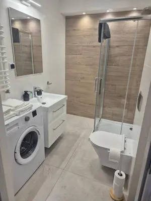 a bathroom with a washing machine and a shower at Megga Apartament z Garażem, FV in Skawina