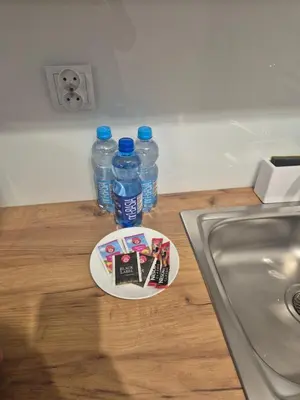 two bottles of water and a plate on a counter at Megga Apartament z Garażem, FV in Skawina