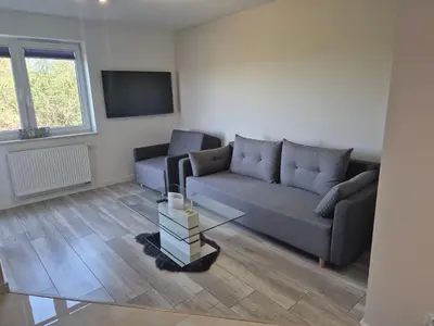 a living room with a couch and a tv at Megga Apartament z Garażem, FV in Skawina