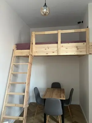 a room with a bunk bed and a table and chairs at Klimatyczna Antresola nad Wisłą in Kraków
