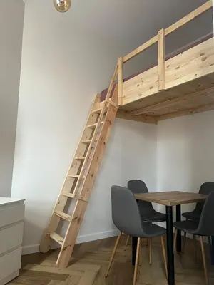 a loft bed in a room with a table and chairs at Klimatyczna Antresola nad Wisłą in Kraków