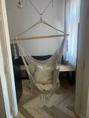 a hammock chair in a room with a bench at Klimatyczna Antresola nad Wisłą in Kraków