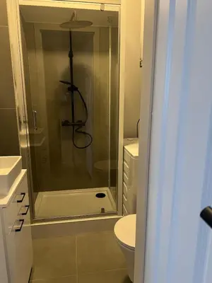 a bathroom with a glass shower with a toilet at Klimatyczna Antresola nad Wisłą in Kraków