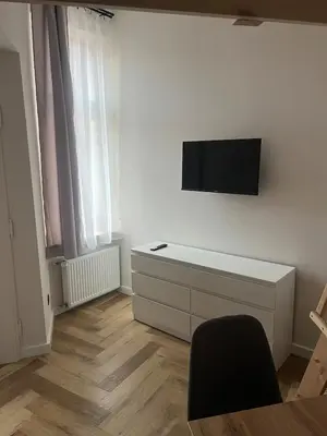 a living room with a tv on a white wall at Klimatyczna Antresola nad Wisłą in Kraków