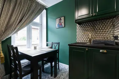 a kitchen with a table and a window and green walls at Malila Premium Apartments Cracow Lubicz 14 in Kraków