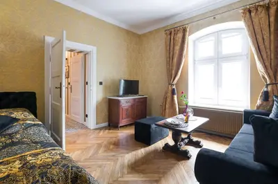 a bedroom with a bed and a table and a window at Malila Premium Apartments Cracow Lubicz 14 in Kraków