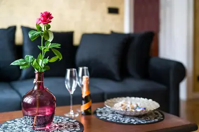 a vase with a rose in it on a table at Malila Premium Apartments Cracow Lubicz 14 in Kraków