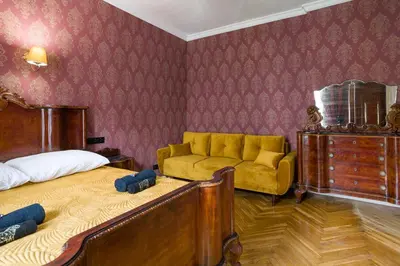 a bedroom with a bed and a yellow couch at Malila Premium Apartments Cracow Lubicz 14 in Kraków