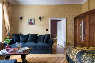 a living room with a blue couch and a table at Malila Premium Apartments Cracow Lubicz 14 in Kraków