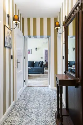 a hallway with striped walls and a door with a mirror at Malila Premium Apartments Cracow Lubicz 14 in Kraków