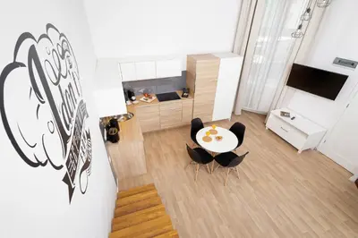 a living room with a table and chairs at Dietla Studio with a mezzanine in the center of Kraków by Noclegi Renters in Kraków