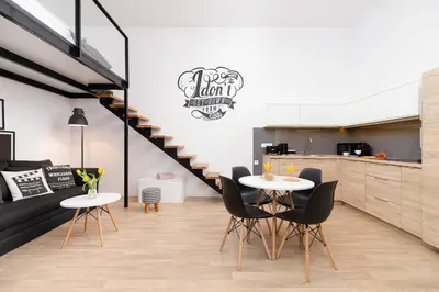 a kitchen and dining room with two tables and a staircase at Dietla Studio with a mezzanine in the center of Kraków by Noclegi Renters in Kraków