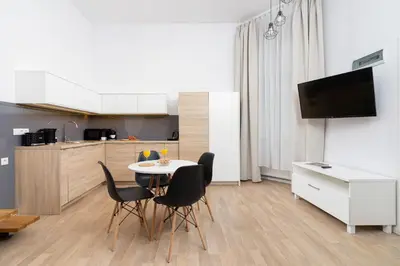 a kitchen and dining room with a table and chairs at Dietla Studio with a mezzanine in the center of Kraków by Noclegi Renters in Kraków