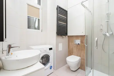 a bathroom with a sink and a washing machine at Dietla Studio with a mezzanine in the center of Kraków by Noclegi Renters in Kraków