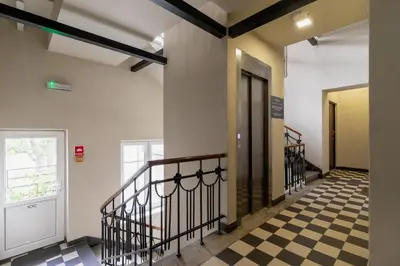 a hallway with a checkered floor and a door at Dietla Studio with a mezzanine in the center of Kraków by Noclegi Renters in Kraków