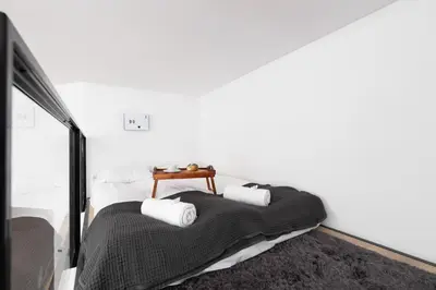 a bedroom with a bed with a table on it at Dietla Studio with a mezzanine in the center of Kraków by Noclegi Renters in Kraków